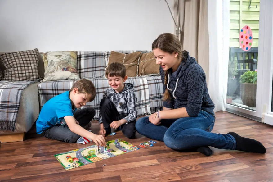 Eine Babysitterin SRK spielt mit 2 Kindern. 